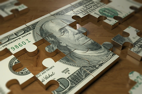 Puzzle of $100 bill on table.