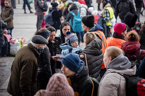 A crowd of people standing outside a train station in Lviv, Ukraine.
