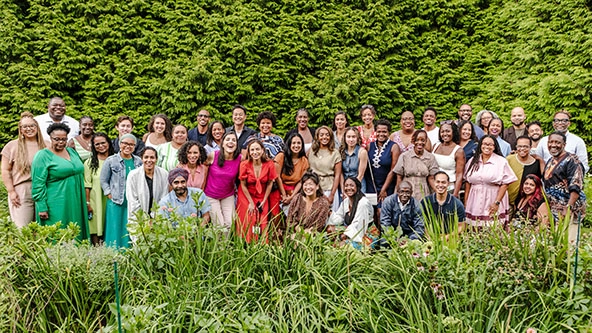 a racially diverse group of women and men standing together facing the camera