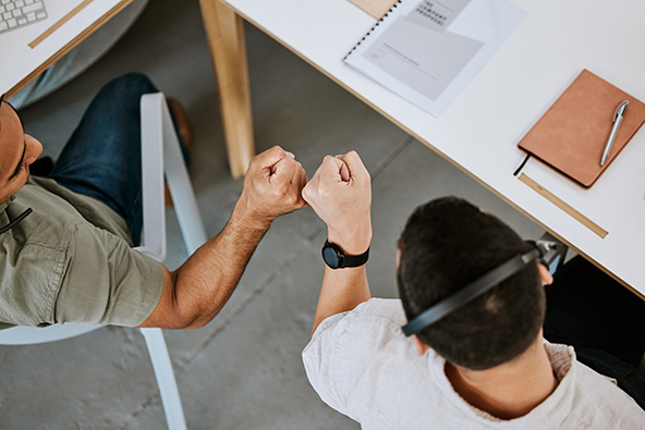 Two colleagues fist bump in the office