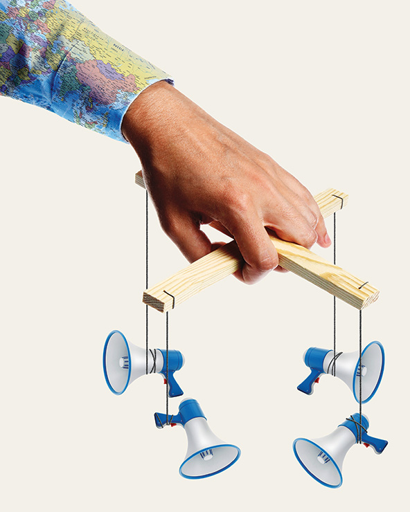 hand holding marionette strings with bullhorns attached to them