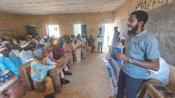 A man with Tracka addresses a group of community members in Niger State
