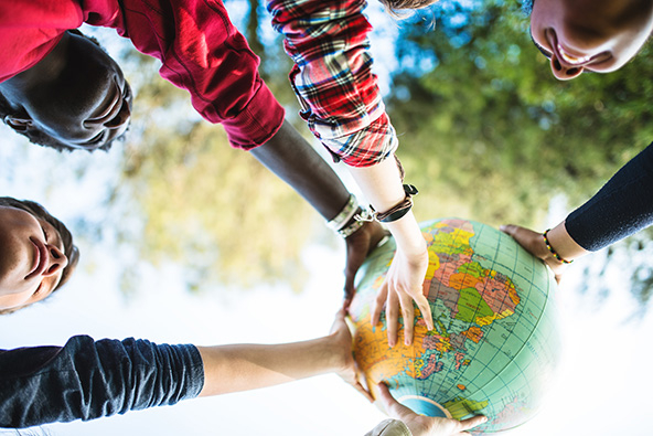 College students smiling with globe