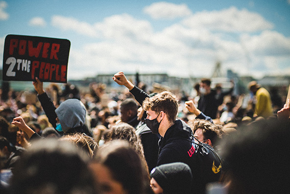 A white protester showing support by raising his fist for the Black Lives Matter demonstration in Cologne, Germany.