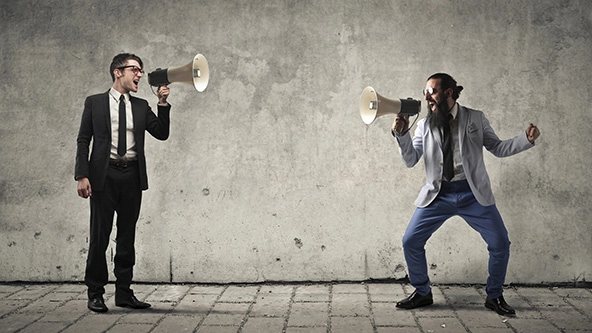 Two man are screaming with each other with megaphones in their hands