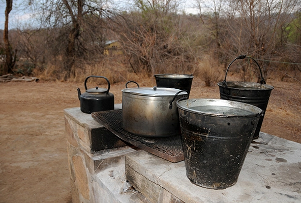 Pots and a tea kettle on an outdoor stove