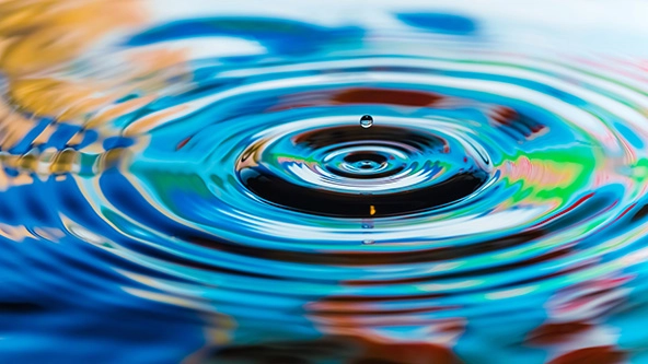 Multicolored water drop and its ripples, close-up