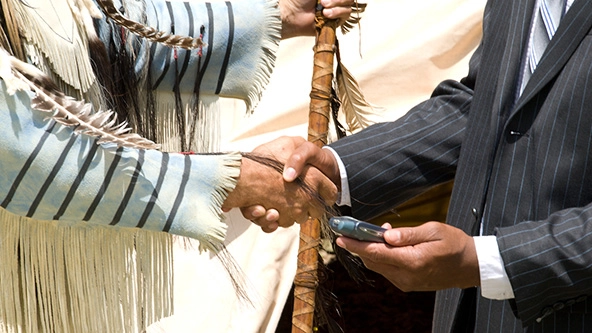 Native American man and businessman shaking hands