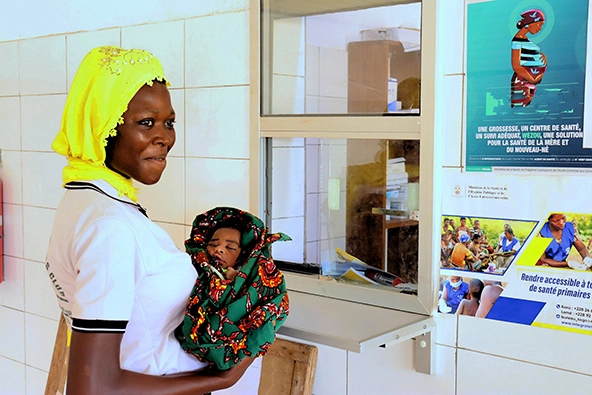 Young African woman holding her baby wrapped in a blanket