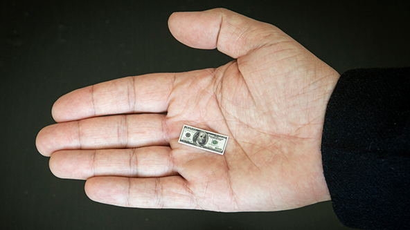 tiny $100 bill in the palm of a hand