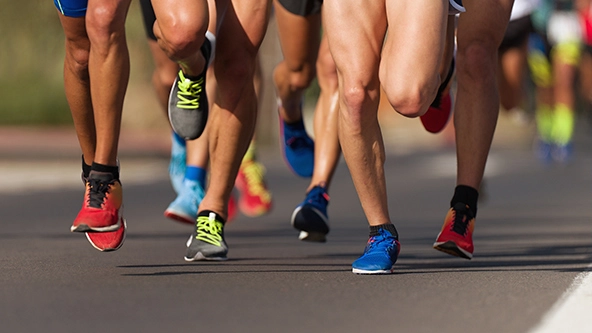 Marathon runners' feet hitting the pavement