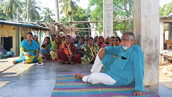 People sitting under shelter listening to presentation