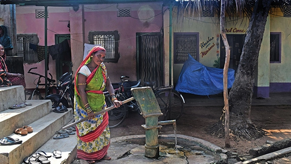 Woman standing by a water pump