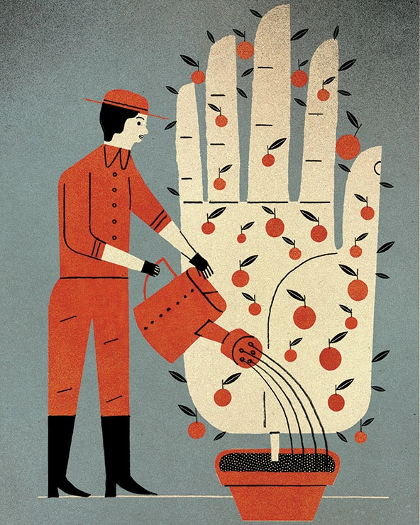 Gardner watering a hand-shaped plant with fruit in a pot