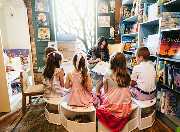 children sit around woman reading a storybook in a bookstore
