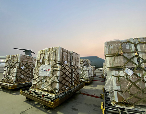 pallets of USAID supplies on a runway