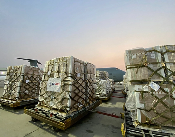 pallets of USAID supplies on a runway