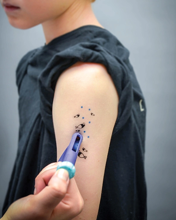 Arm with a temporary tattoo and syringe with insulin